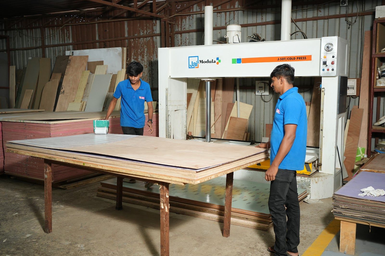 Workers preparing a panel for laminate pressing at the AS9 factory
