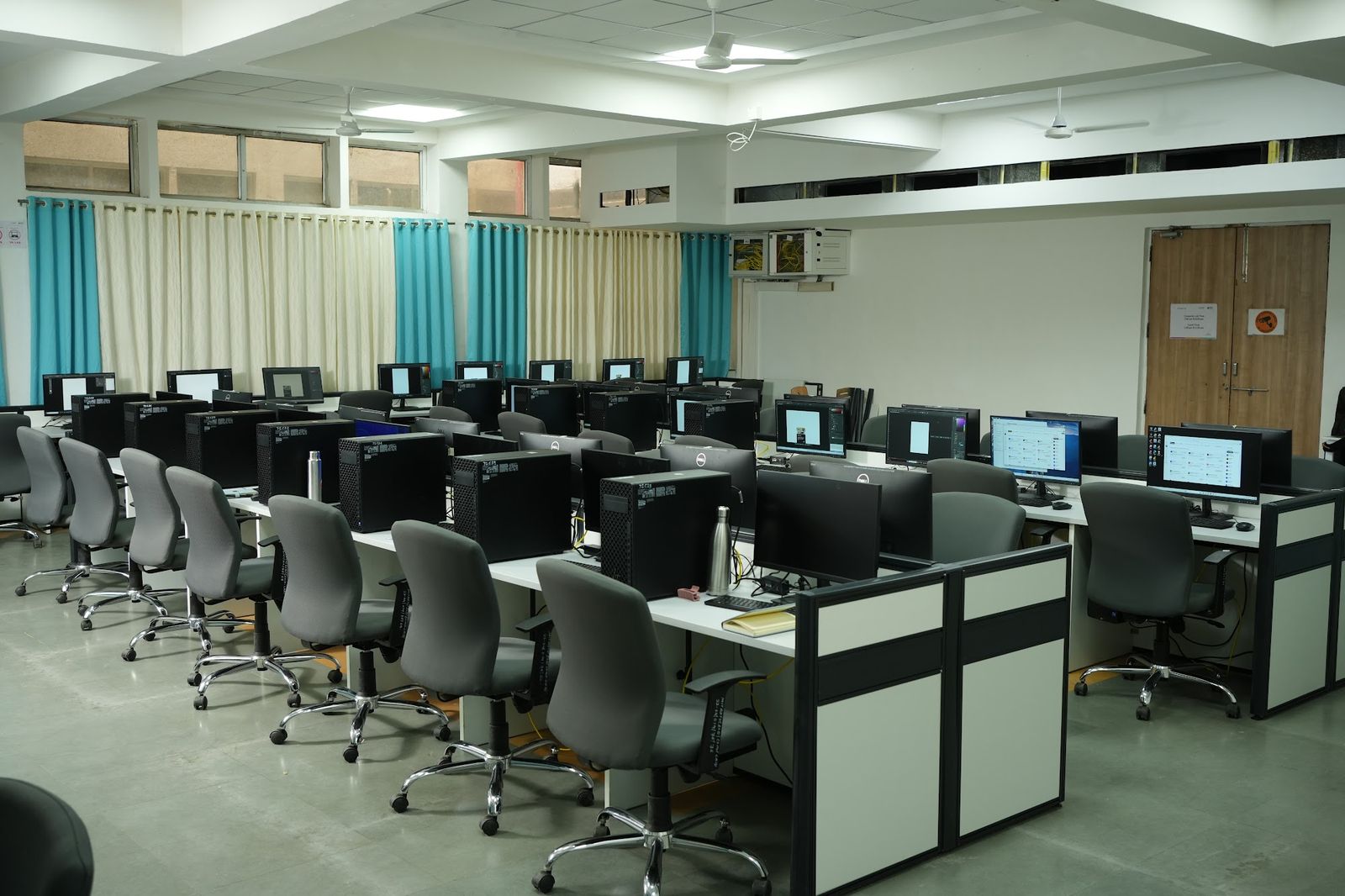 Computer lab with grey-framed workstations and panel partitions