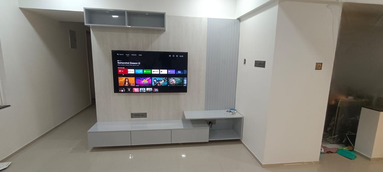 Grey TV unit with open shelving and wall panelling