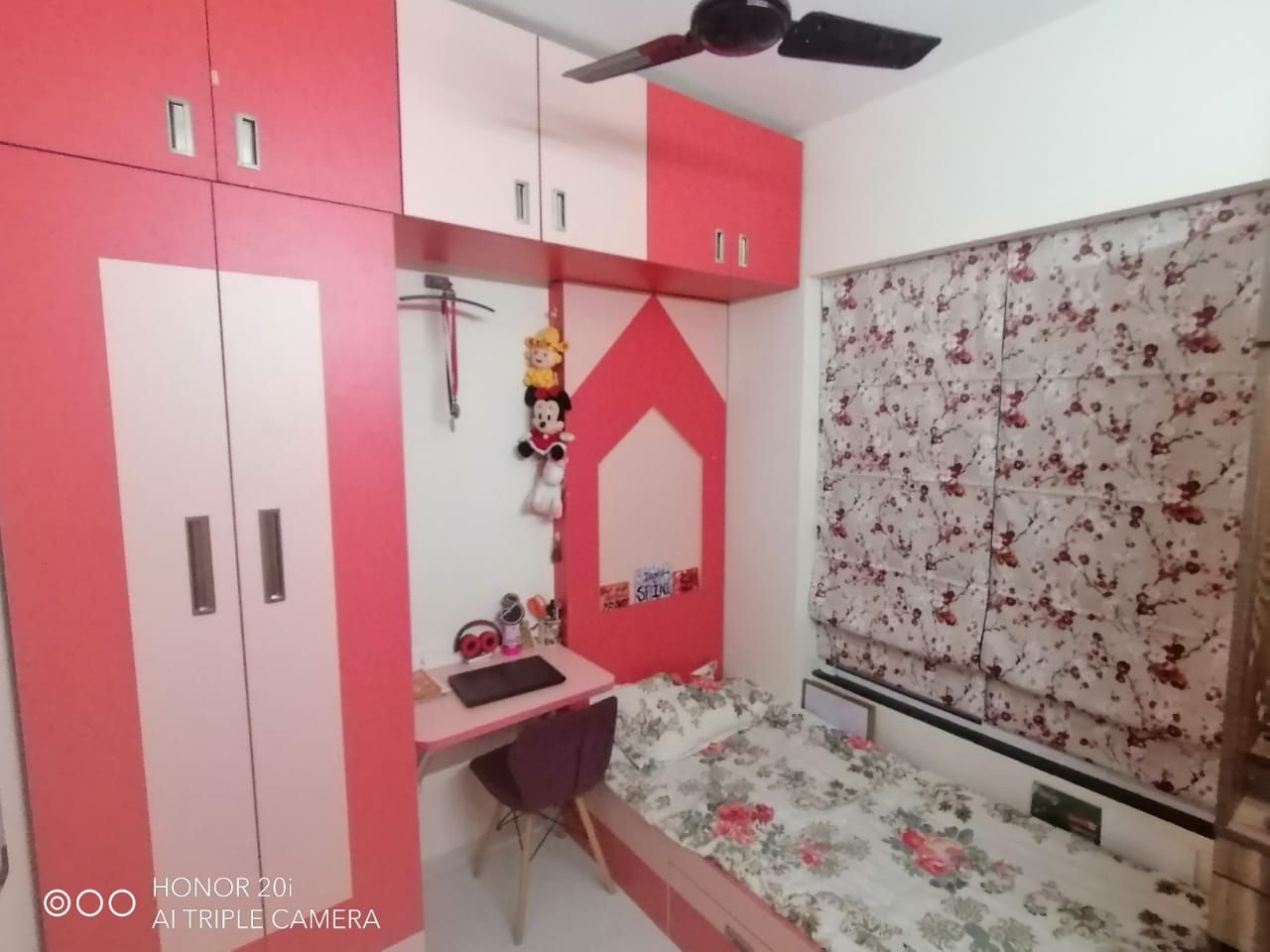Kids room in pink and white with wardrobe, study unit and bed