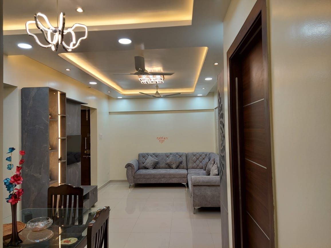 Living and dining area with a false ceiling, cove lighting and an L-shaped sofa