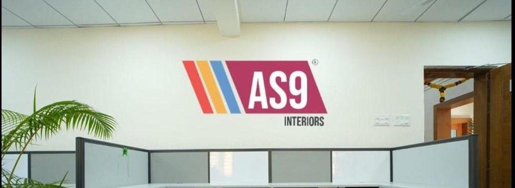 Office workstations made by AS9 Interiors, with the AS9 logo on the wall
